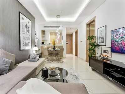 a living room with a couch and a tv at Savis Homes - Stylish 1BR in Business Bay with Burj Khalifa View in Damac Paramount Tower in Dubai