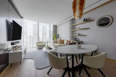 a living room with a table and a tv at The Opus residences 1 bedroom city view in Dubai