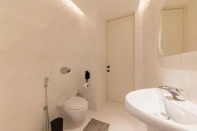 a white bathroom with a toilet and a sink at The Opus residences 1 bedroom city view in Dubai