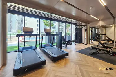 a gym with treadmills and exercise equipment in a building at Splendour Living 1BR at Azizi Riviera in Dubai