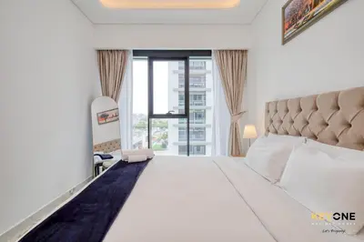 a bedroom with a large white bed with a large window at Splendour Living 1BR at Azizi Riviera in Dubai