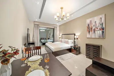 a bedroom with a bed and a table and a dining room at FIRST CLASS Studio Cozy with City Vibes in Dubai