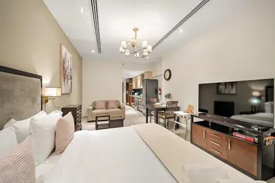 a bedroom with a bed and a living room at FIRST CLASS Studio Cozy with City Vibes in Dubai