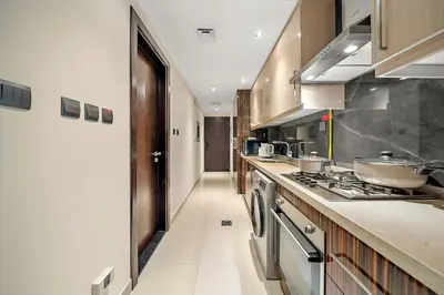 a large kitchen with a stove and a hallway at FIRST CLASS Studio Cozy with City Vibes in Dubai