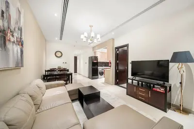 a living room with a couch and a flat screen tv at FIRST CLASS 1BR Stylish , Modern Comfort in Dubai