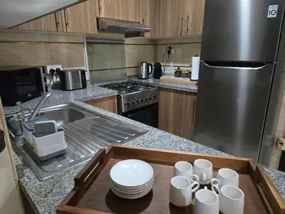 a kitchen with a tray with cups and plates on it at Dar Al Noor Apartment in Dubai