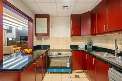 a kitchen with wooden cabinets and a sink and a counter top at Luxe 3BR and Maid Room with Panoramic Dubai Eye View - JBR Beach in Dubai