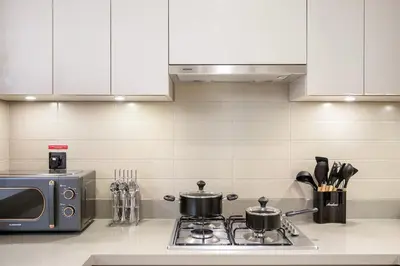 a kitchen with two pots on a stove with a microwave at FIRST CLASS 2BR Luxury Living at Waves Grande in Dubai