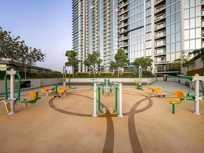 a playground in a city with a large building at FIRST CLASS 2BR Luxury Living at Waves Grande in Dubai