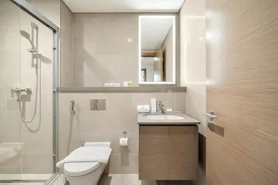 a bathroom with a toilet and a sink and a shower at FIRST CLASS 2BR Luxury Living at Waves Grande in Dubai