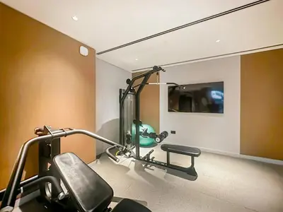 a room with a gym with a treadmill at FIRST CLASS 2BR Luxury Living at Waves Grande in Dubai