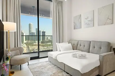 a living room with a bed and a large window at FIRST CLASS 1BR Minimalist Elegance in Dubai