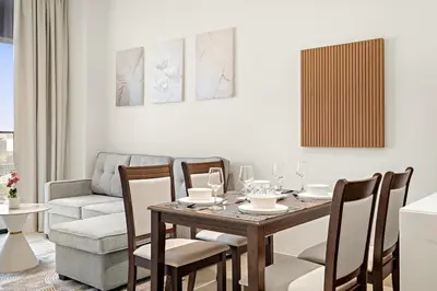 a dining room with a table and chairs and a couch at FIRST CLASS 1BR Minimalist Elegance in Dubai