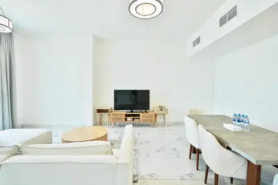 a living room with white furniture and a flat screen tv at Premium 3-BR Serene Canal View High Floor in Dubai