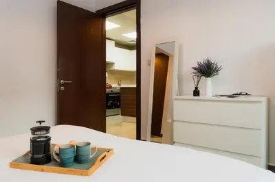 a tray with cups and a coffee maker on a bed at Peaceful - Charming - Urban Hideaway in Dubai