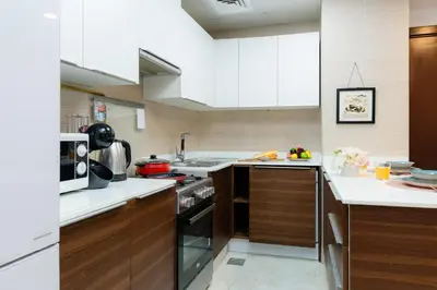a kitchen with white cabinets and a stove top oven at Peaceful - Charming - Urban Hideaway in Dubai