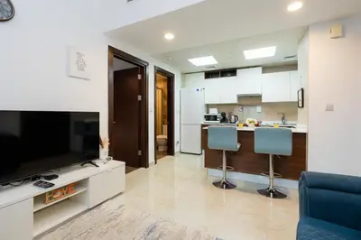 a living room with a television and a kitchen at Peaceful - Charming - Urban Hideaway in Dubai