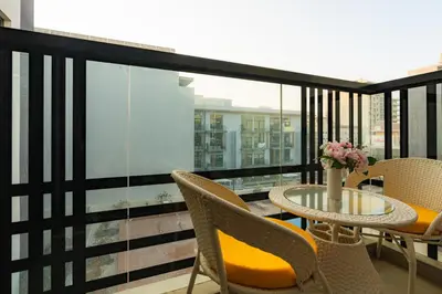 a balcony with chairs and a table with a vase of flowers at Peaceful - Charming - Urban Hideaway in Dubai