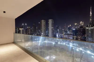 a room with a view of a city at night at Chic 1-Bedroom Retreat in Heart of Business Bay in Dubai