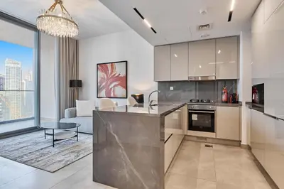 a kitchen with a counter and a living room at Chic 1-Bedroom Retreat in Heart of Business Bay in Dubai