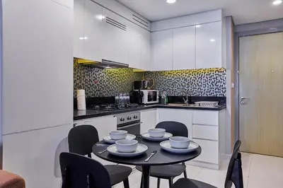 a kitchen with a table and chairs in a kitchen at Luxury 2BR with Skyline Views Prime Business Bay Location in Dubai