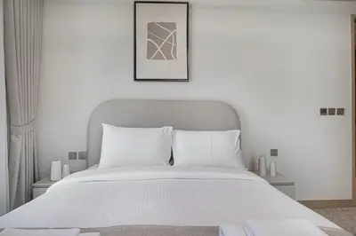 a bedroom with a white bed and a picture on the wall at Vida Dubai Mall! Excellent Amenities, Mall Connected! in Dubai