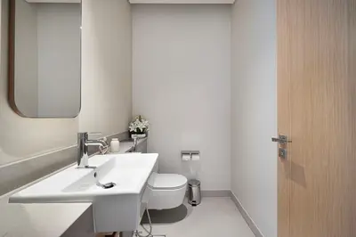 a bathroom with a sink and a toilet and a mirror at Vida Dubai Mall! Excellent Amenities, Mall Connected! in Dubai