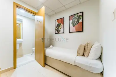 a room with a white couch and a bathroom at Iconic Burj Khalifa View 2BR with Assistant Room, Steps from Dubai Mall and Beside a Park, Bellevue Towers 1, Downtown Dubai by Deluxe Holiday Homes in Dubai