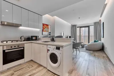 a kitchen with a washer and dryer in a room at Luxury 1BR in Central Business Bay in Dubai