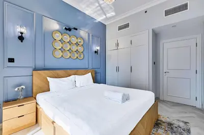a bedroom with a large white bed and blue walls at Luxury 1BHK with Stunning Canal View Business Bay in Dubai