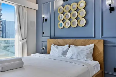 a bedroom with a large bed with a blue wall at Luxury 1BHK with Stunning Canal View Business Bay in Dubai