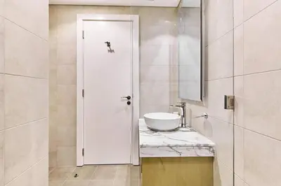 a white bathroom with a sink and a mirror at Elegant 2BR Apartment Heart of Business Bay High Floor in Dubai
