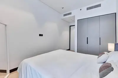 a white bedroom with a white bed and a closet at Khalifa View Luxe 1BHK in Dubai