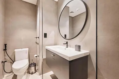 a bathroom with a toilet and a sink and a mirror at Khalifa View Luxe 1BHK in Dubai