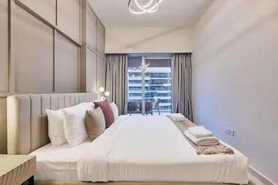 a bedroom with a large white bed with a window at Cityscape Comforts 2BR in Dubai