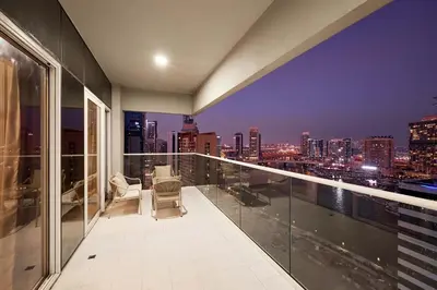 a balcony with a view of the city at night at Cityscape Comforts 2BR in Dubai