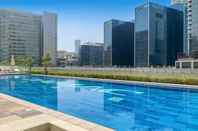 a large blue swimming pool on top of a building at Cityscape Comforts 2BR in Dubai
