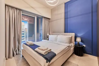 a bedroom with a large bed with a blue wall at Cityscape Comforts 2BR in Dubai