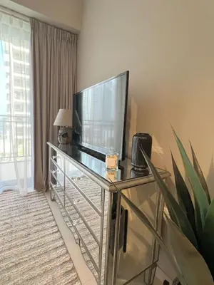 a living room with a television on a glass table at Cozy 1BR in Zada Tower Business Bay in Dubai