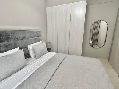 a bedroom with a large white bed with a mirror at Cozy 1BR in Zada Tower Business Bay in Dubai