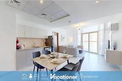 a kitchen and dining room with a table and chairs at Vacationer l 1 Bedroom Perched on the 19th Floor l Free Pool, Gym Access in Dubai