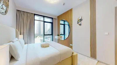 a bedroom with a large bed and a mirror at Vacationer l Stunning 1 Bedroom l City View l Pool, Gym Access in Dubai