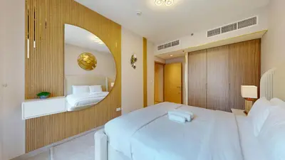 a bedroom with a large white bed and a mirror at Vacationer l Stunning 1 Bedroom l City View l Pool, Gym Access in Dubai