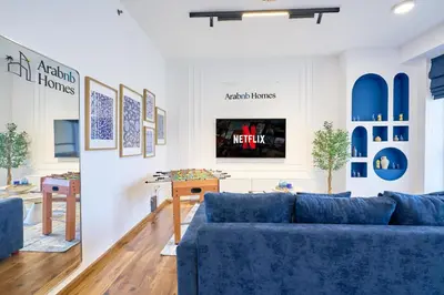 a living room with blue couches and a tv at Full Ocean & Palm Views Apartments in JBR Beachfront with Dubai Eye Views in Dubai