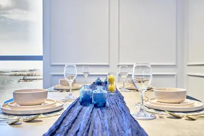 a table with wine glasses and a blue table cloth at Full Ocean & Palm Views Apartments in JBR Beachfront with Dubai Eye Views in Dubai