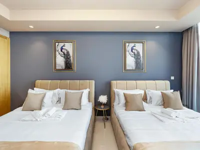 two beds in a room with blue walls at ElysianSky Burj Khalifa Views 3 Bedroom Apartment at Paramount Hotel Midtown with 64th Floor Rooftop Pool in Dubai