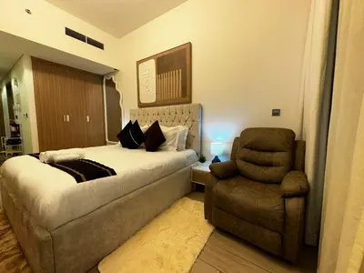 a bedroom with a bed and a couch and a chair at Ramaira Homes Azizi Riviera 26 by Vacay Xeal in Dubai