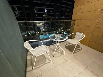 a balcony with a table and chairs on a building at Ramaira Homes Azizi Riviera 26 by Vacay Xeal in Dubai