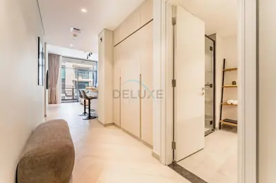 a room with a hallway with a couch and a table at Studio Near Ras Al Khor Wildlife Sanctuary with Partial Creek Views, Just Minutes from Downtown Attractions, Wilton Park Residences, Sobha Hartland by Deluxe Holiday Homes in Dubai