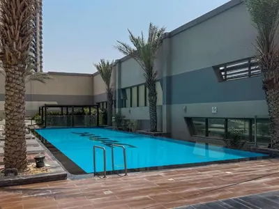 a large swimming pool with stools in front of a building at Frank Porter - The Vogue, Business Bay in Dubai